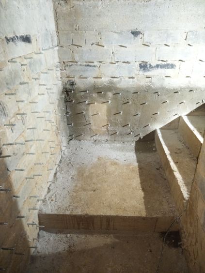 Ściana wewnętrzna przy schodach naszpikowana pakerami iniekcyjnymi